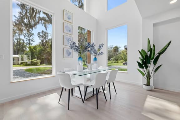 Flooded with natural light, this open concept living and dining space is perfect for relaxing, sharing meals, and enjoying the clean modern coastal vibe.